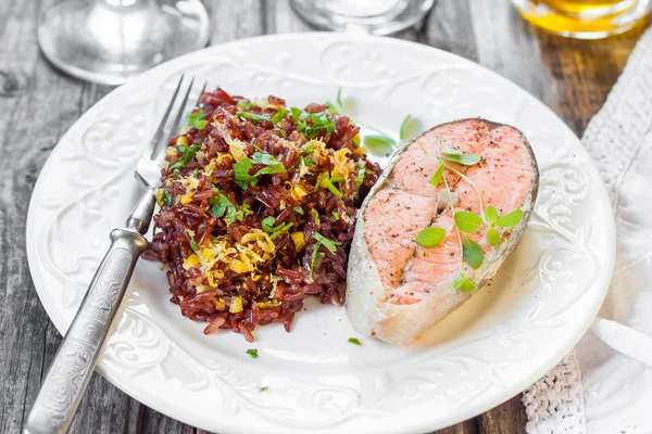 Bife de salmão com arroz vermelho. Arroz vermelho com raspas de salmão e limão — Fotografia de Stock