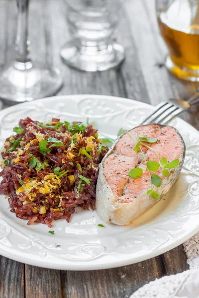 Bife de salmão com arroz vermelho. Arroz vermelho com raspas de salmão e limão — Fotografia de Stock