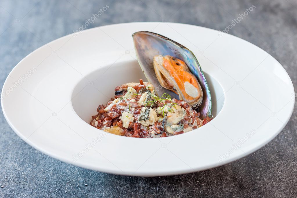 creamy mussels with red rice and cheese sauce. mussels with blue cheese and red rice