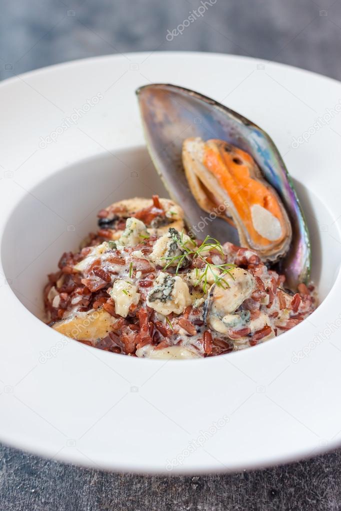 creamy mussels with red rice and cheese sauce. mussels with blue cheese and red rice