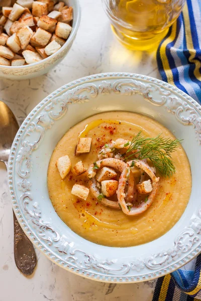 Sopa de crema con guisantes, aros de calamar y galletas saladas. Sopa de guisantes con anillos de calamar — Foto de Stock