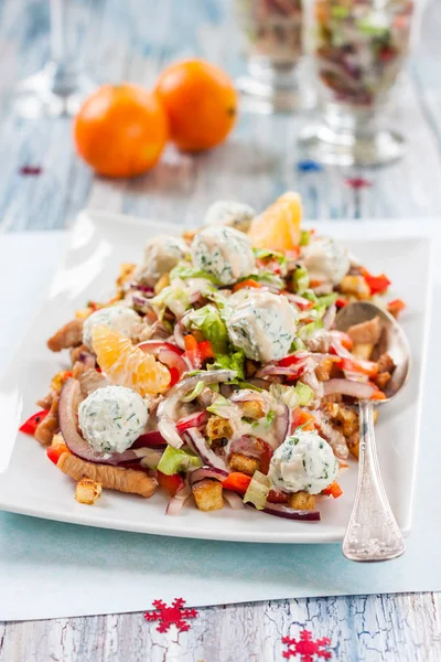 Салат с перцем, курицей, гренками, мандаринами и сырными шариками на новогоднем столе — стоковое фото