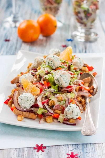 Салат с перцем, курицей, гренками, мандаринами и сырными шариками на новогоднем столе — стоковое фото