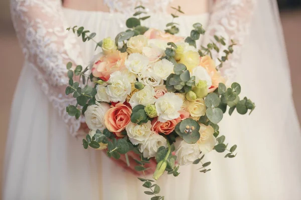 新娘手里拿着一束不同颜色的漂亮的花 穿着一件白色的衣服 — 图库照片