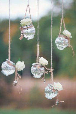 Mini vazo ve tavandan sarkan çiçek buketleri şeklinde orijinal düğün çiçekleri.