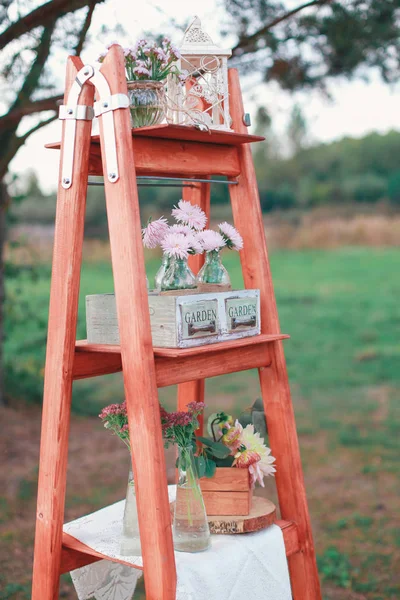 Rustic wedding photo zone. Hand made wedding decorations includes Photo Booth, wooden barrels and boxes, lanterns, suitcases and white flowers