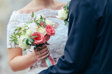 Güzel gelin elinde renkli bir buket tutuyor. Renkli çiçeklerin güzelliği. Bir demet çiçek yakın plan. Gelin aksesuarları. Kız için kadın dekorasyonu. Evlilik ve evli çiftler için detaylar