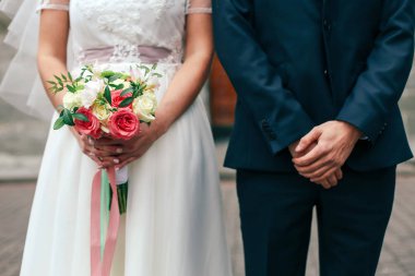 Güzel gelin elinde renkli bir buket tutuyor. Renkli çiçeklerin güzelliği. Bir demet çiçek yakın plan. Gelin aksesuarları. Kız için kadın dekorasyonu. Evlilik ve evli çiftler için detaylar