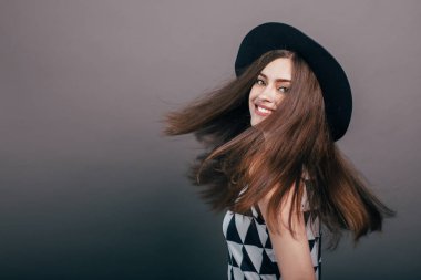 Güzel moda olan kadın siyah şapka ve gözlük gri arka plan üzerinde moda makyaj. Modeli şık gözlük takıyor kameraya bakıyor. Kadın moda, güzellik kavramı.