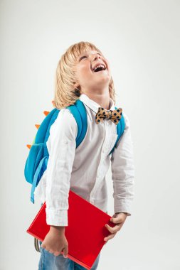 Kitaplar ve beyaz arka plan üzerinde izole elma ile mutlu okul çocuğu portresi. Eğitim, izole. Okul okul öncesi