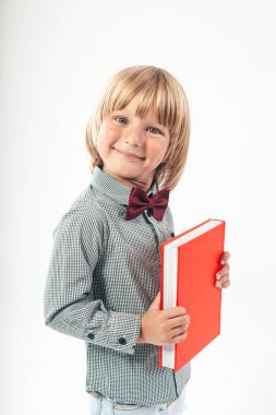 Kitaplar ve beyaz arka plan üzerinde izole elma ile mutlu okul çocuğu portresi. Eğitim, izole. Okul okul öncesi