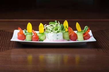 Kiraz domates ve salatalık ahşap arka plan üzerinde beyaz tabakta salatası