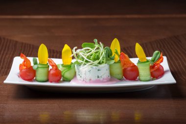 Kiraz domates ve salatalık ahşap arka plan üzerinde beyaz tabakta salatası