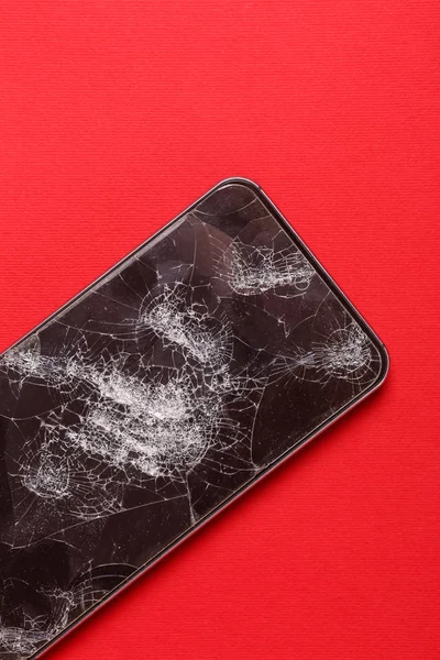 Broken display on cellphone on color background.