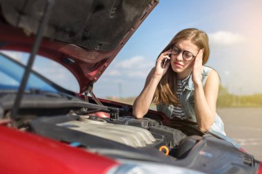 Ülke yolda kırık bir araba yakınındaki kız cep telefonundan arıyor.