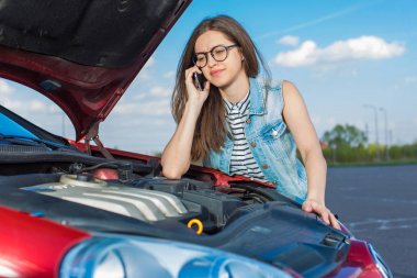 Ülke yolda kırık bir araba yakınındaki kız cep telefonundan arıyor.