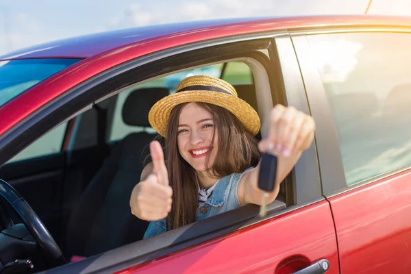 Driver woman smiling showing new car keys and car. Happy woman driver showing car keys and leaning on car door