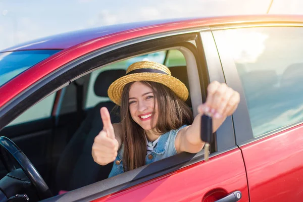 Driver woman smiling showing new car keys and car. Happy woman driver showing car keys and leaning on car door