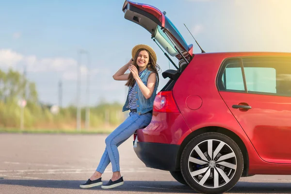 Hatchback araba açık güneşli arka plan ile oturan genç kadın Gezgin 