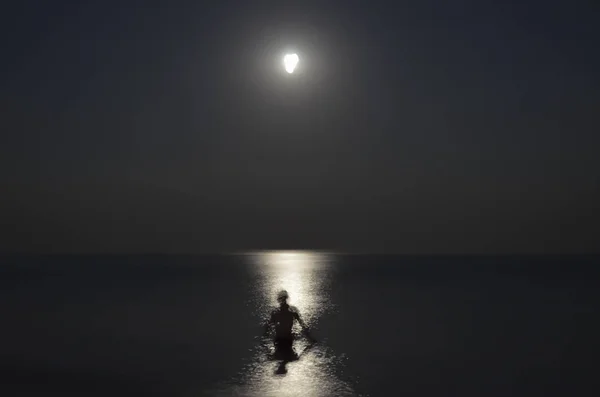 Gece denizde adam silüeti