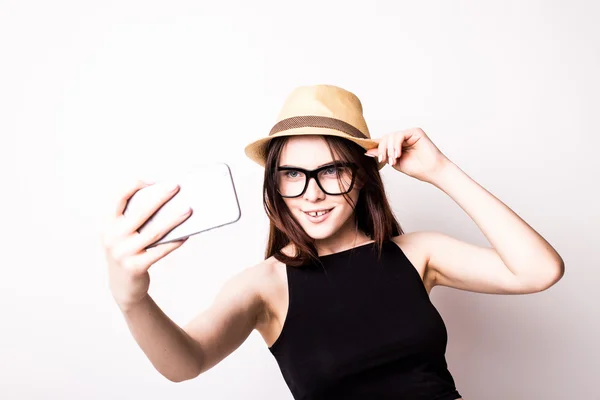 Молодая привлекательная девушка делает селфи фото портрет с мобильного телефона или камеры в темных очках шляпу и летнее платье в шикарный модный турист — стоковое фото