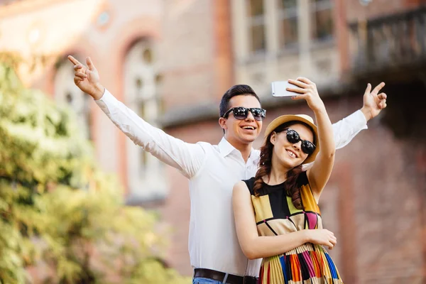 Glada unga älskande par står utomhus tillsammans och tittar på mobiltelefonen tillsammans — Stockfoto