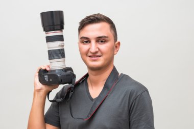 gri bir arka plan üzerinde izole kamera tutan adam