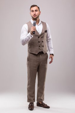 Takım elbise şarkı üzerinde mikrofon ile enerji genç adam.