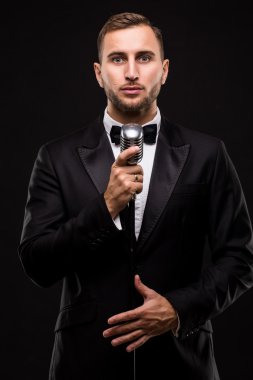 Yakışıklı erkek takım elbise şarkı mikrofon ile 