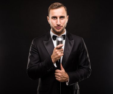 Yakışıklı erkek takım elbise şarkı mikrofon ile 