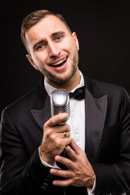 Yakışıklı erkek takım elbise şarkı mikrofon ile 