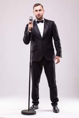 Takım elbise şarkı mikrofon üzerinde genç adam