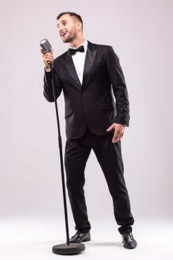 Takım elbise şarkı mikrofon üzerinde genç adam
