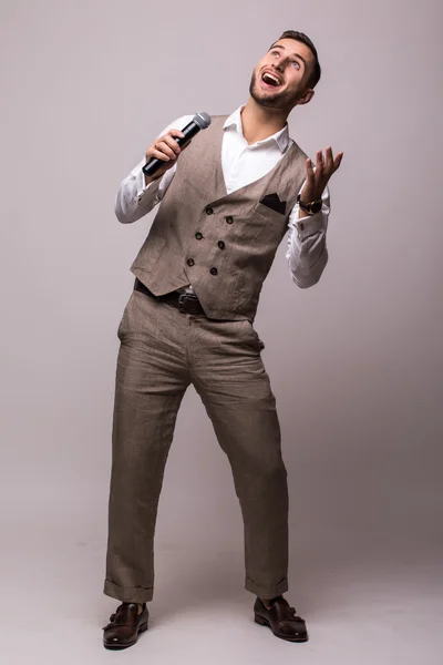 Joven en traje cantando sobre el micrófono con energía . — Foto de Stock