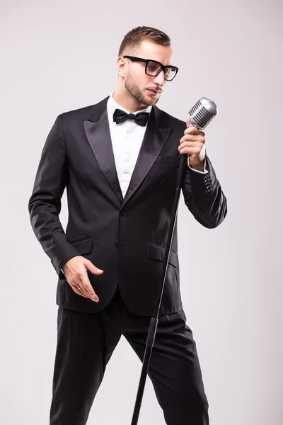 Young man in suit singing over the microphone — Stock Photo, Image
