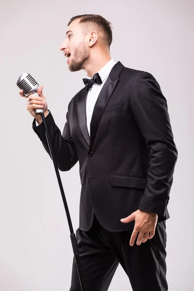 Young man in suit singing over the microphone — Stock Photo, Image