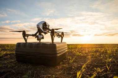 Uzaktan kumanda ile quadrocopter dron. Derma günbatımı karşı karanlık siluet.