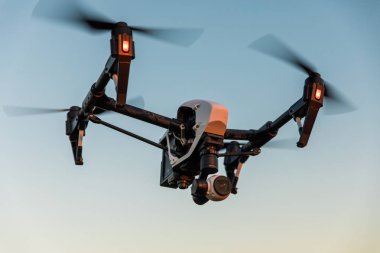 Uzaktan kumanda ile quadrocopter dron. Derma günbatımı karşı karanlık siluet.
