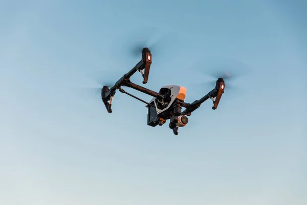 Drone quadrocopter con telecomando. Silhouette scura contro il tramonto colorato . — Foto Stock