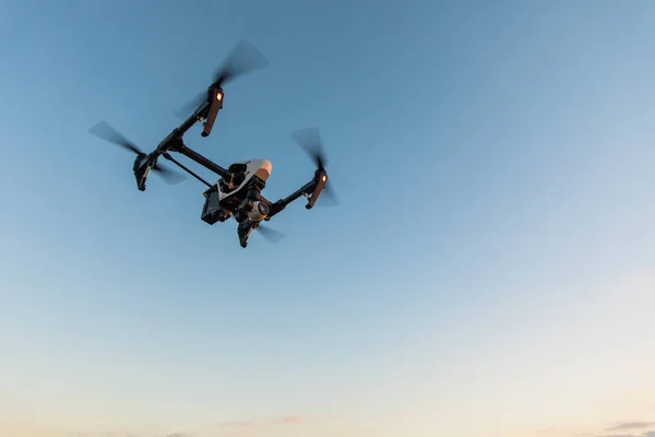 Drone quadrocopter con telecomando. Silhouette scura contro il tramonto colorato . — Foto Stock