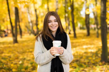 Genç kız içki kahve sarı sonbahar güneşli Park