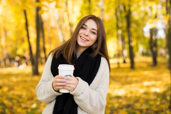 Junges Mädchen trinkt Kaffee im herbstlich gelben sonnigen Park — Stockfoto