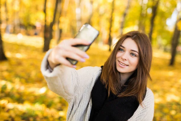 Smile Girl macht Selfie mit Handy im sonnigen Herbstpark — Stockfoto