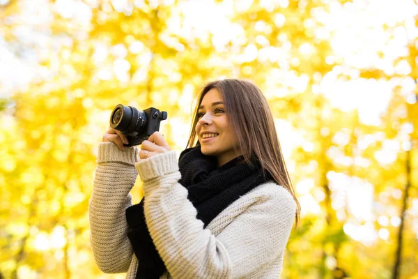 Girl take photo with camera in yellow autumn park — Stock Photo, Image