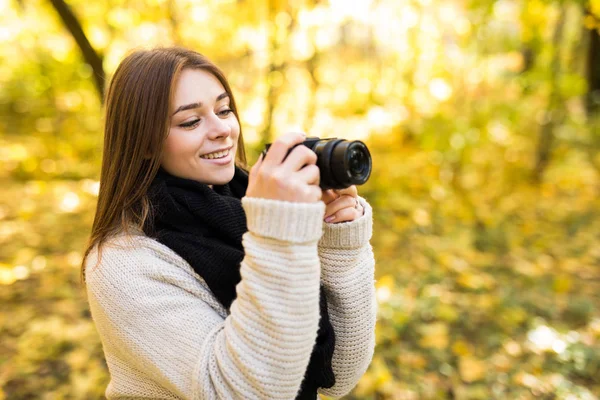 Girl take photo with camera in yellow autumn park — Stock Photo, Image