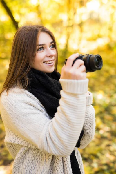 Girl take photo with camera in yellow autumn park — Stock Photo, Image