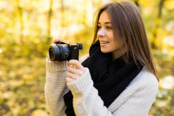 Girl take photo with camera in yellow autumn park — Stock Photo, Image