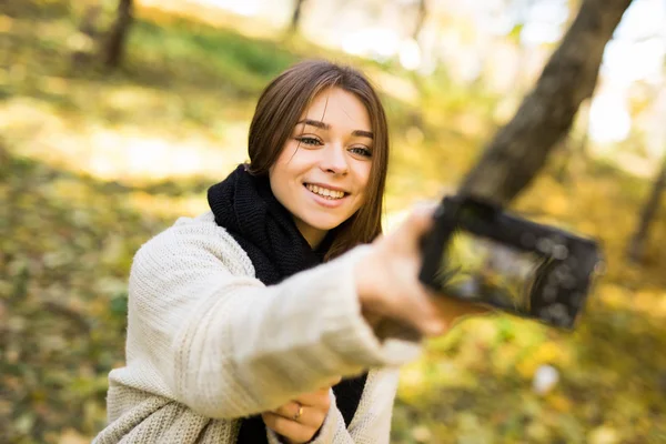 Fata face o fotografie selfie cu camera in parcul galben de toamna — Fotografie, imagine de stoc