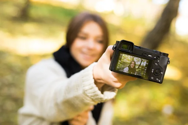 Chica tomar foto selfie con cámara en el parque amarillo de otoño —  Fotos de Stock