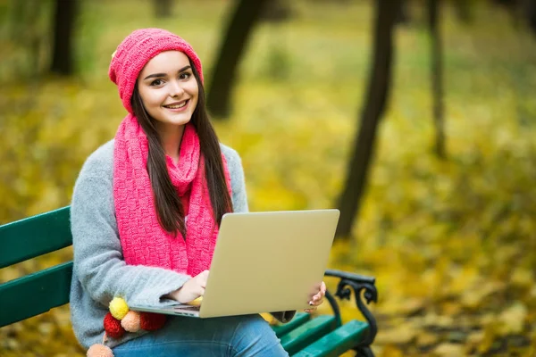 Милая женщина с ноутбуком в осеннем парке . — стоковое фото